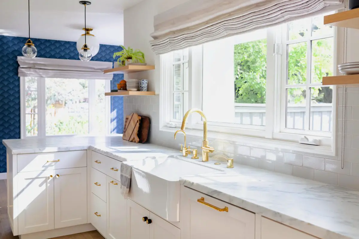 Image of a kitchen in a home with a large window over the drain. Source: adobe stock