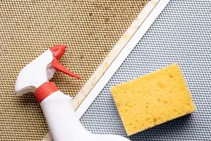 Image of of a dirty and clean mesh hood filter with spray bottle and yellow sponge. Source: Adobe Stock