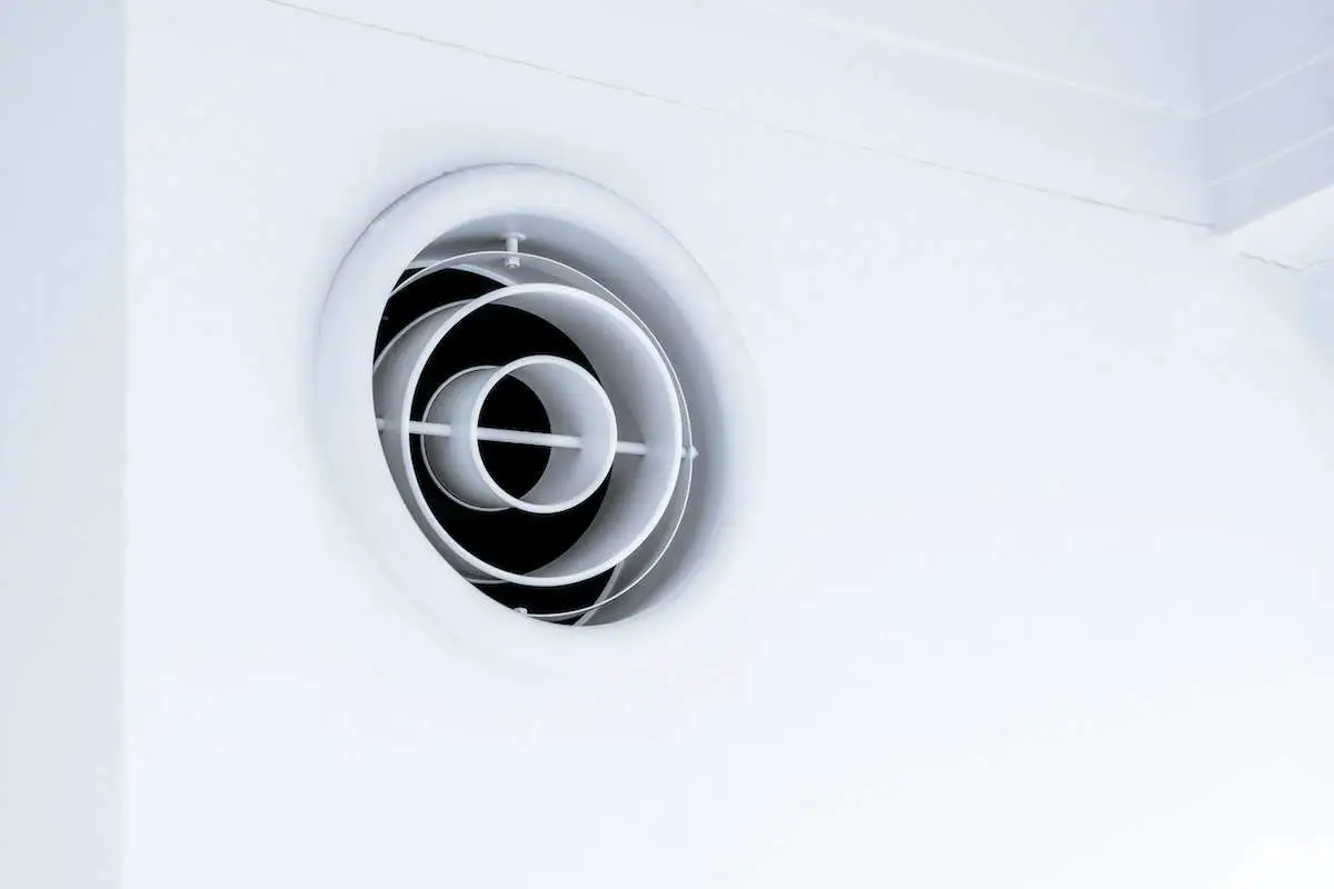 Hvac ventilation system exhaust on white wall. Source: meritt thomas, unsplash