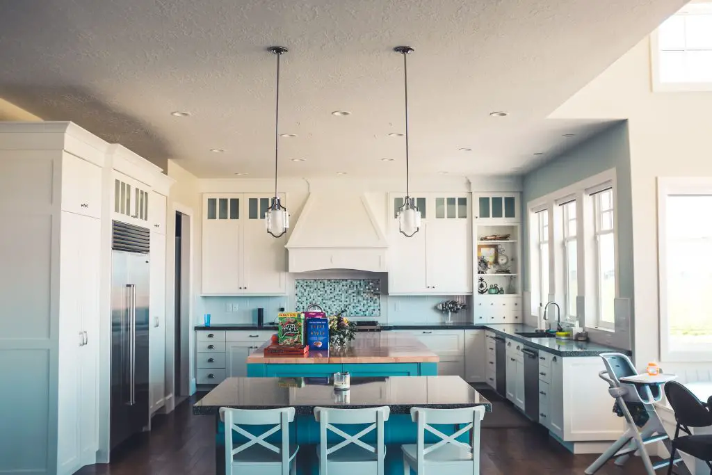 Image of a large kitchen with a ducted insert range hood inside a custom range hood. Source: enclosure neonbrand, unsplash