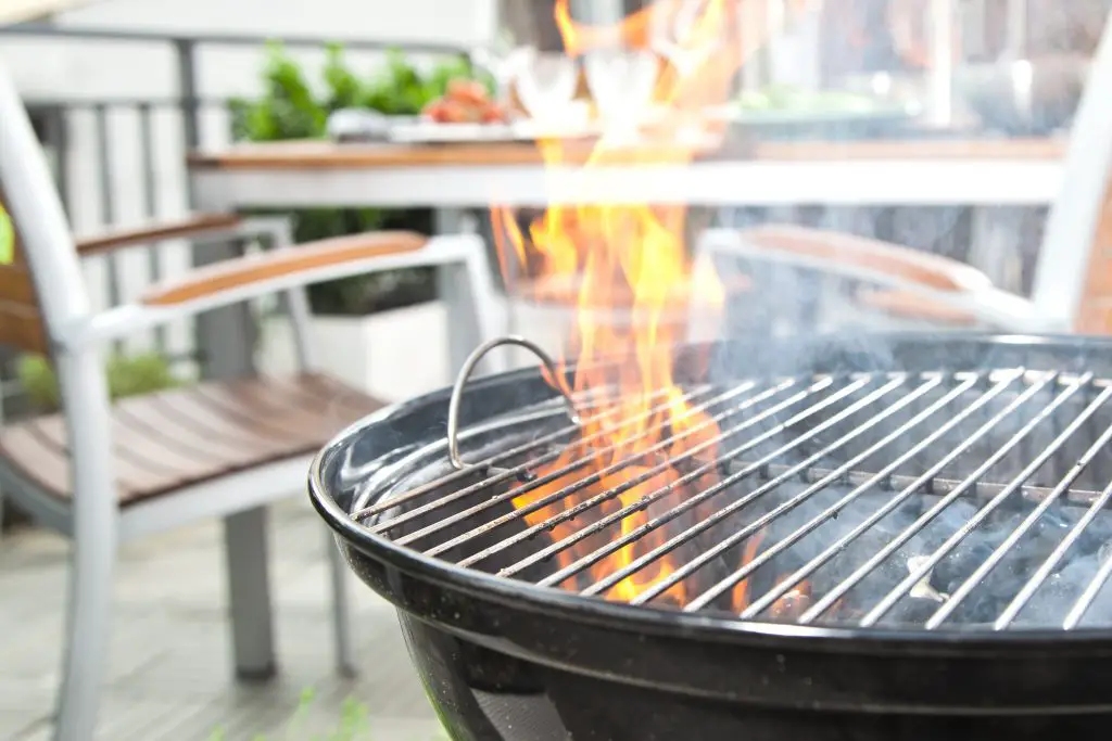 Image of a fiery and smoky charcoal grill. Source: adobe stock