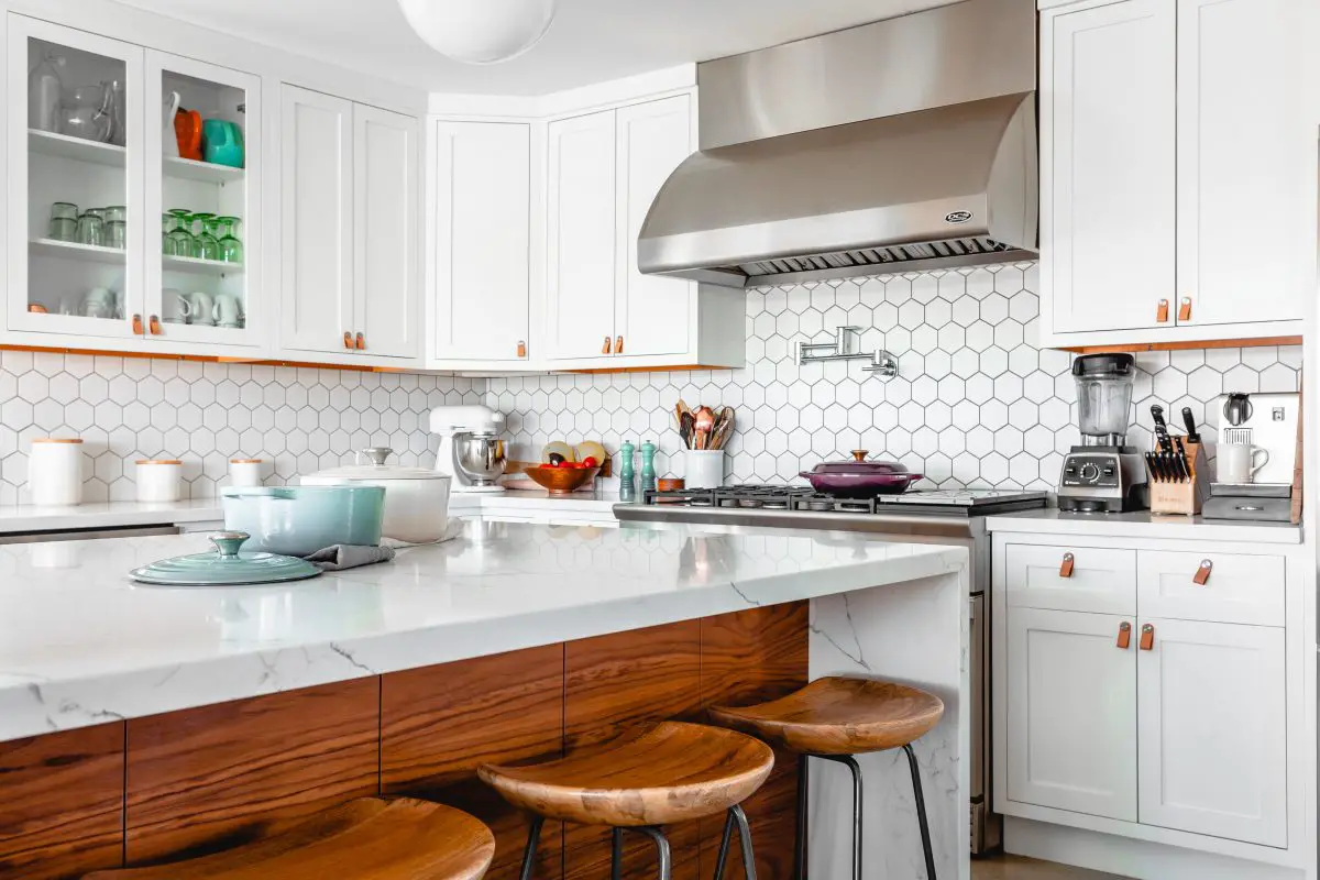 Image of a beautiful white kitchen with a professional range hood. Source: unsplash