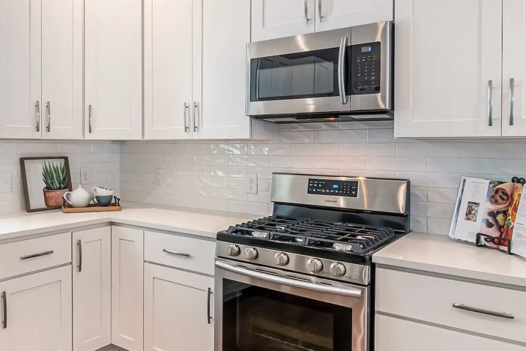 Image of a kitchen with an otr microwave range hood. Source: pexels