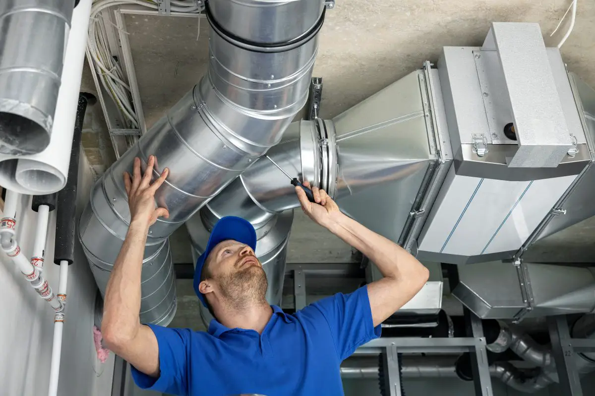 Image of a repair man inspecting a hvac system. Source: adobe stock